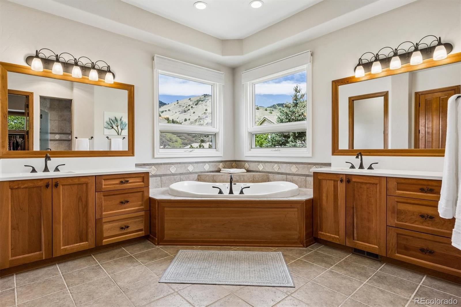16422 Rocky Point Lane Morrison, CO 80465 - Photo 23 of 50 a spacious bathroom with a sink mirror and bathtub
