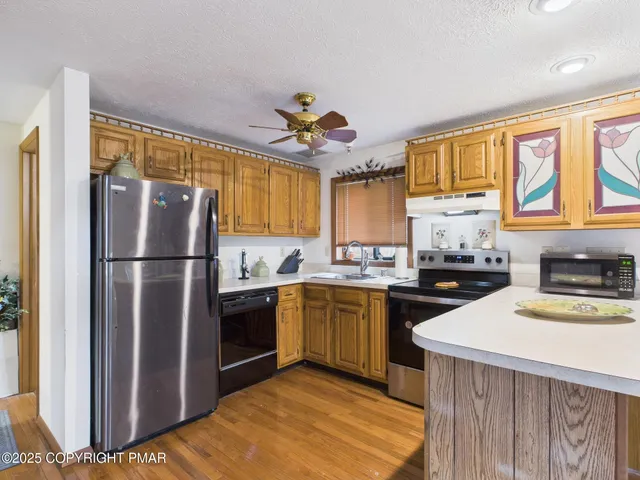 a kitchen with a refrigerator wooden floor and a sink