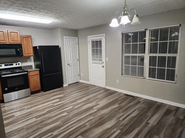 a view of a kitchen with wooden floor and stainless steel appliances