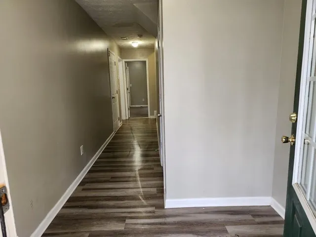 a view of a hallway with wooden floor and staircase