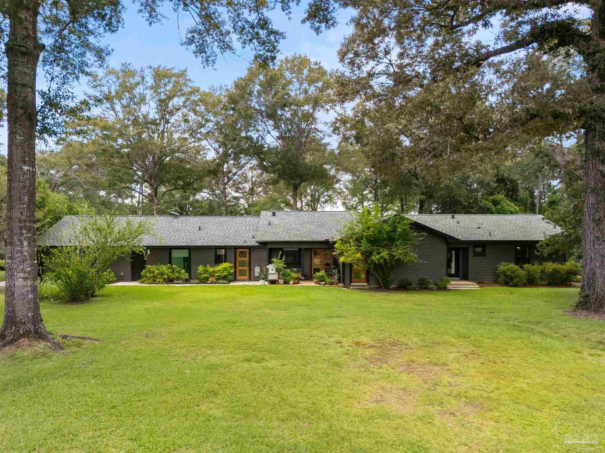 7716 Sunshine Hill Road Molino, FL 32577 - Photo 32 of 37 a view of a house with a yard and sitting area