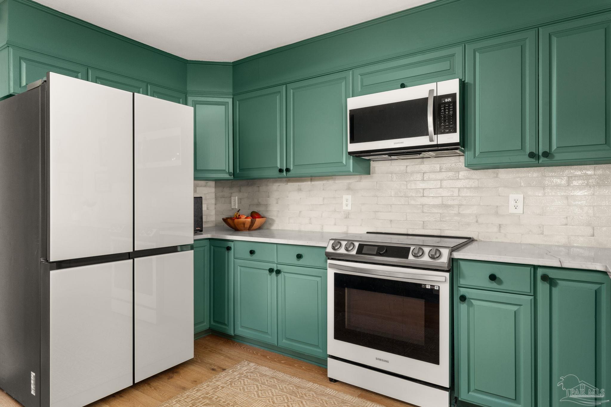 7716 Sunshine Hill Road Molino, FL 32577 - Photo 9 of 37 a kitchen with stainless steel appliances white cabinets white stove a microwave and a refrigerator