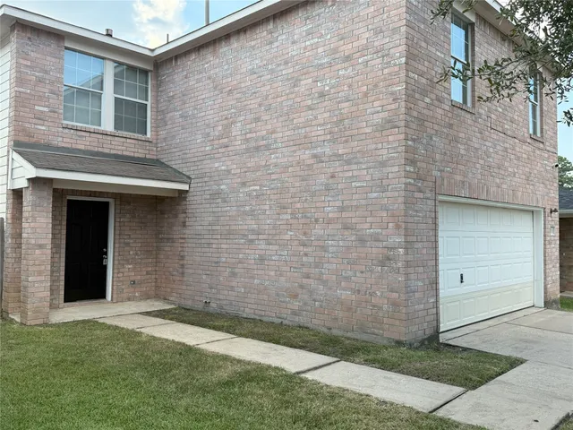 a view of a brick house with a yard