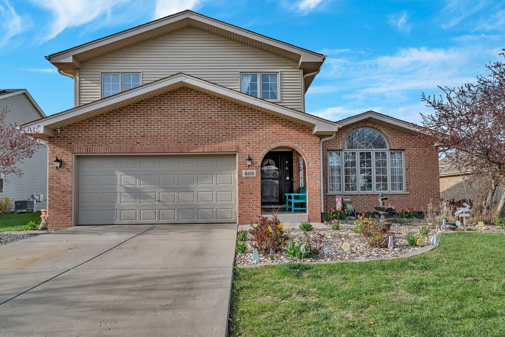 a front view of a house with a garden and yard