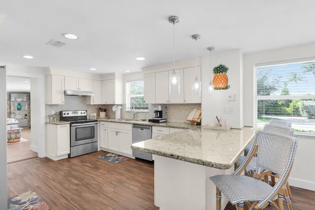 a kitchen with granite countertop white cabinets and white appliances