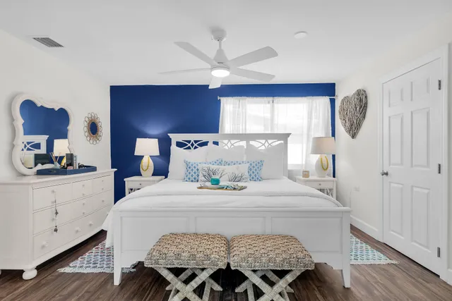 a bedroom with a bed and a large window with wooden floor