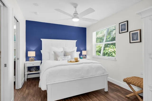 a bedroom with a bed and a flat tv screen on dresser