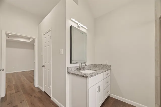 a bathroom with a granite countertop sink and a mirror