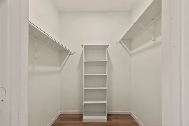 a view of walk in closet with empty racks