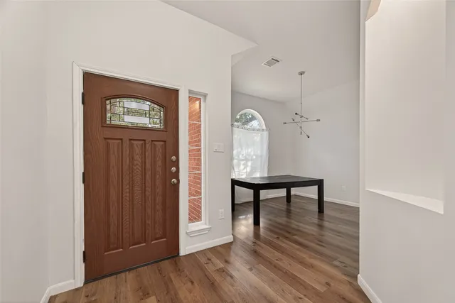 wooden floor with table and chairs