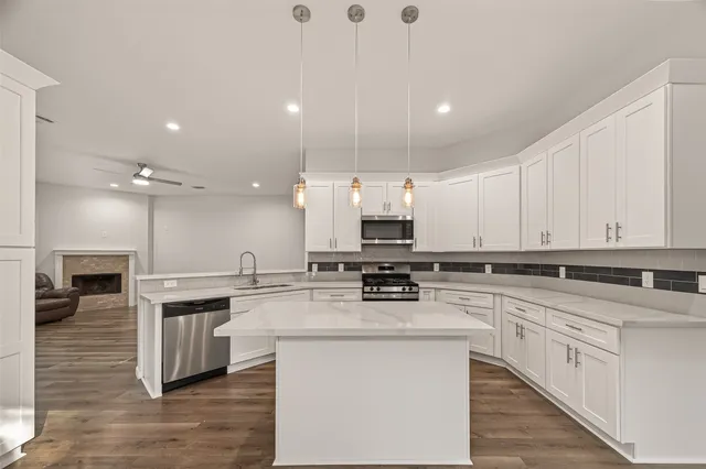a kitchen with stainless steel appliances granite countertop a stove sink and cabinets
