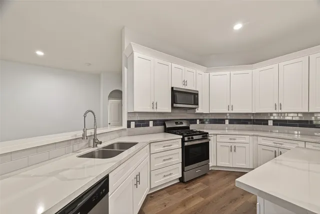 a kitchen with appliances a sink cabinets and a counter top space