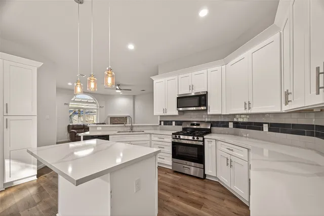 a kitchen with white cabinets appliances and sink
