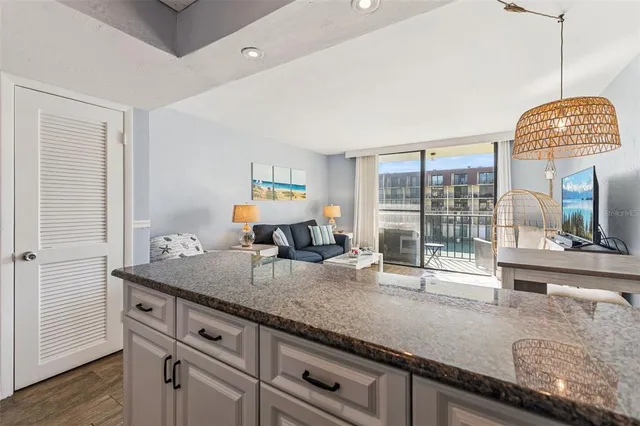 a kitchen with granite countertop a sink a stove and cabinets