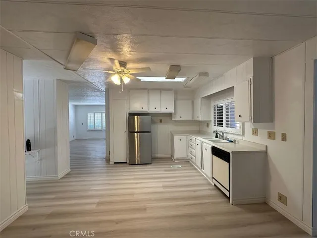 a kitchen with cabinets and wooden floor