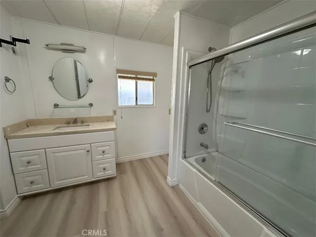 a spacious bathroom with a double vanity sink a mirror a bathtub and shower