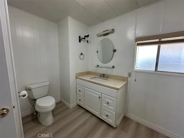 a bathroom with a granite countertop toilet sink and mirror