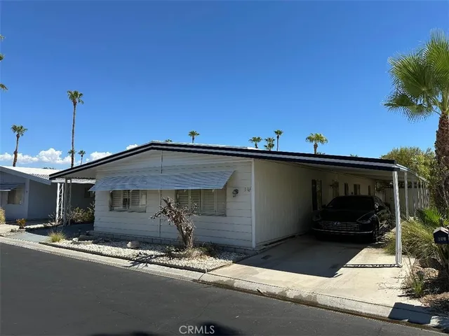a front view of a house with plants