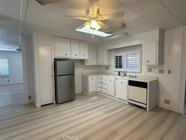 a kitchen with granite countertop white cabinets and white appliances