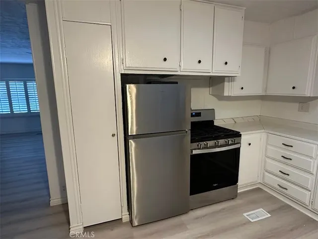 a kitchen with white cabinets and stainless steel appliances