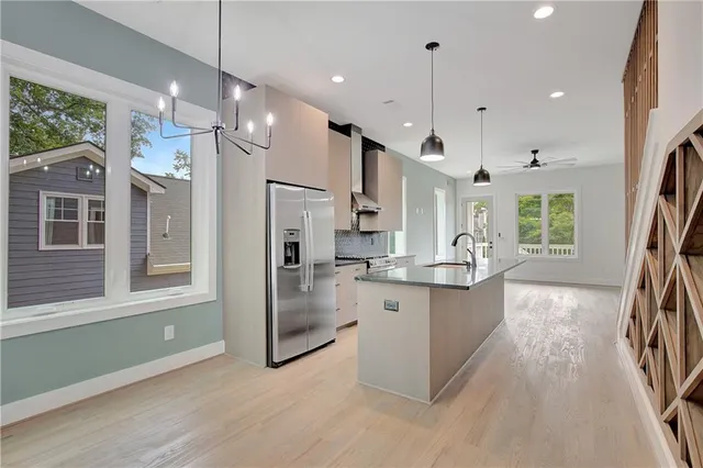 a room with chandelier fan and wooden floor
