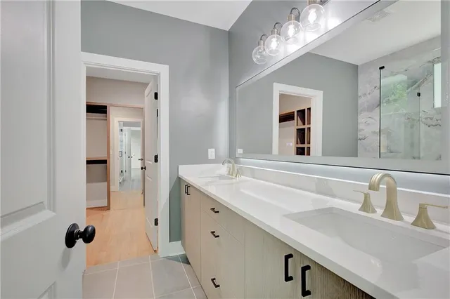 a bathroom with a double vanity sink mirror and shower