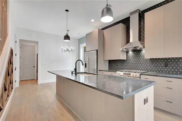 a kitchen with stainless steel appliances granite countertop a sink a stove and a refrigerator