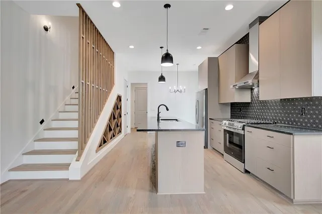 a large kitchen with stainless steel appliances kitchen island a large counter top and a wooden floors