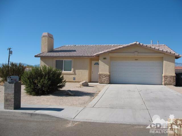13827 Ocotillo Road Desert Hot Springs, CA 92240 - Photo 1 of 15 a front view of a house with a garden