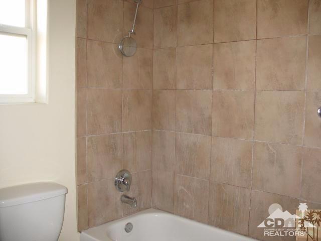 13827 Ocotillo Road Desert Hot Springs, CA 92240 - Photo 7 of 15 a bathroom with a shower and a toilet