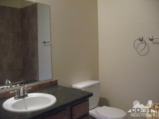 13827 Ocotillo Road Desert Hot Springs, CA 92240 - Photo 10 of 15 a bathroom with a granite countertop sink and a mirror