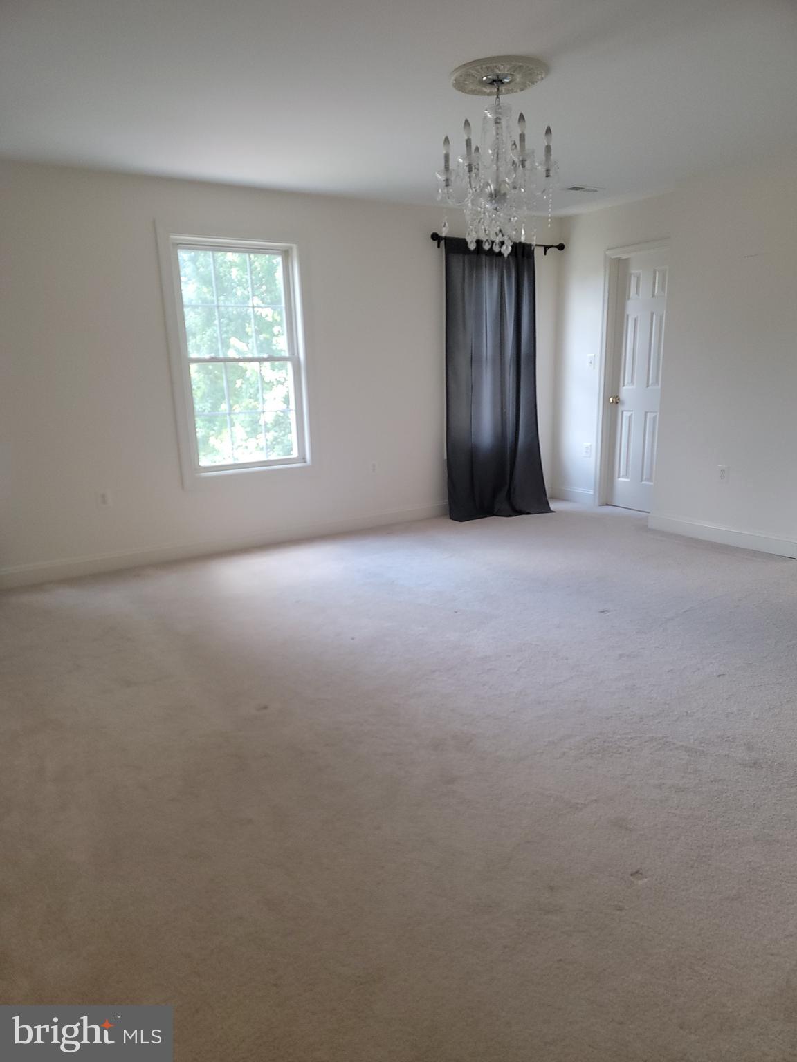 915 Virginia Avenue Culpeper, VA 22701 - Photo 12 of 24 an empty room with a chandelier fan and windows