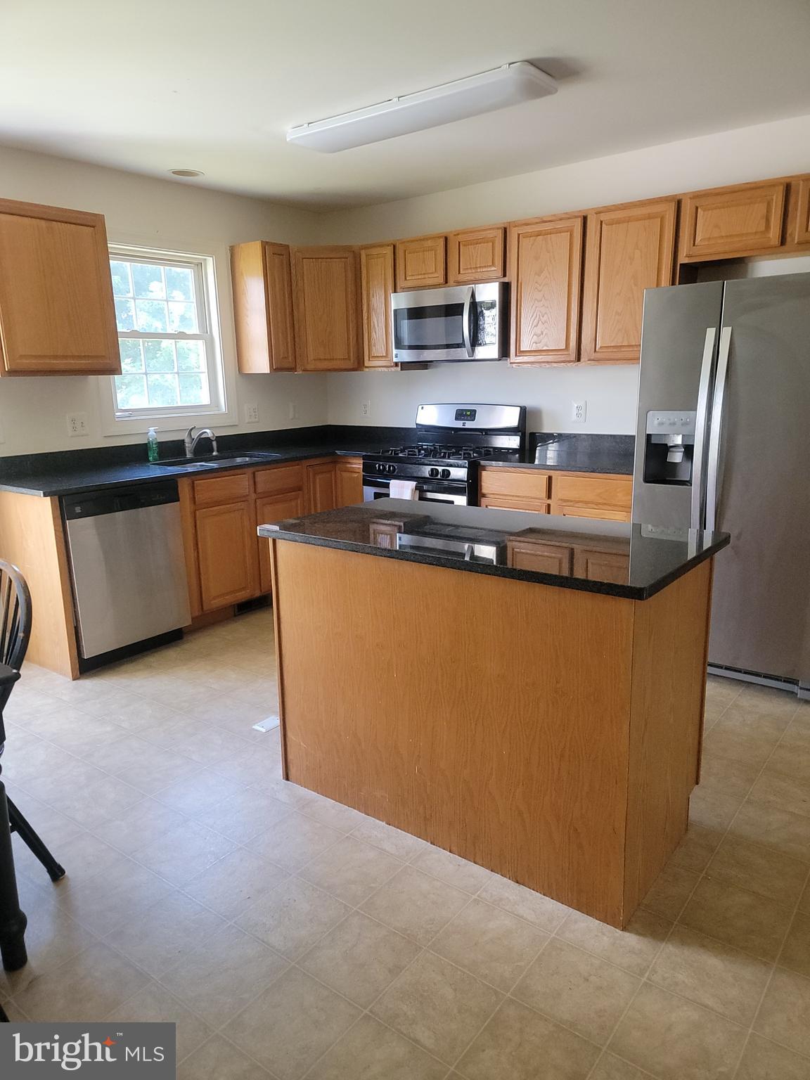 915 Virginia Avenue Culpeper, VA 22701 - Photo 16 of 24 a kitchen with stainless steel appliances granite countertop a sink a stove a refrigerator cabinets and a window