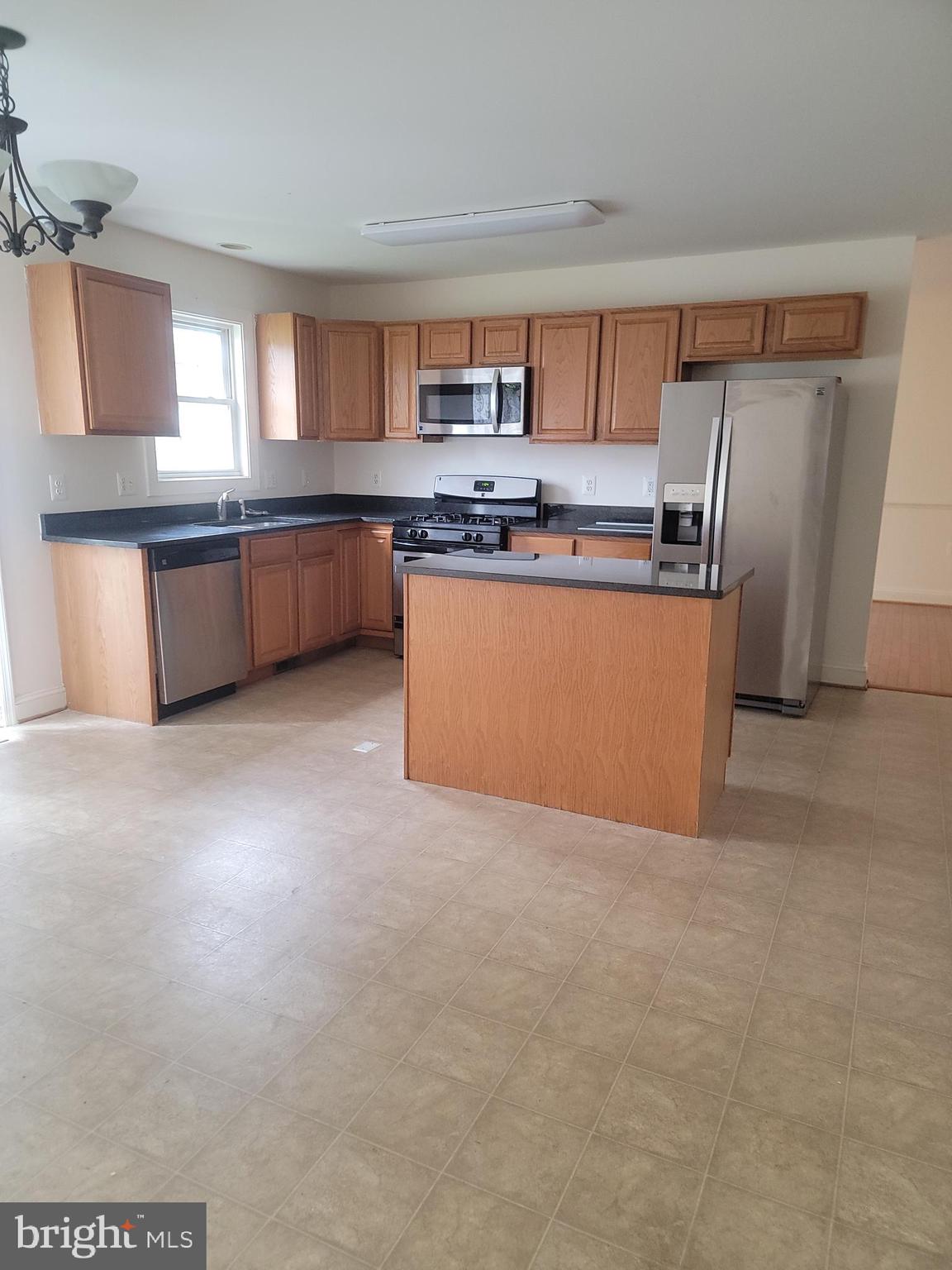 915 Virginia Avenue Culpeper, VA 22701 - Photo 3 of 24 a large kitchen with granite countertop a refrigerator a sink a stove a microwave a counter space and cabinets