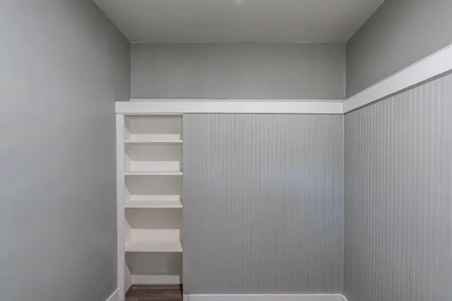 a view of a hallway and a livingroom with a window