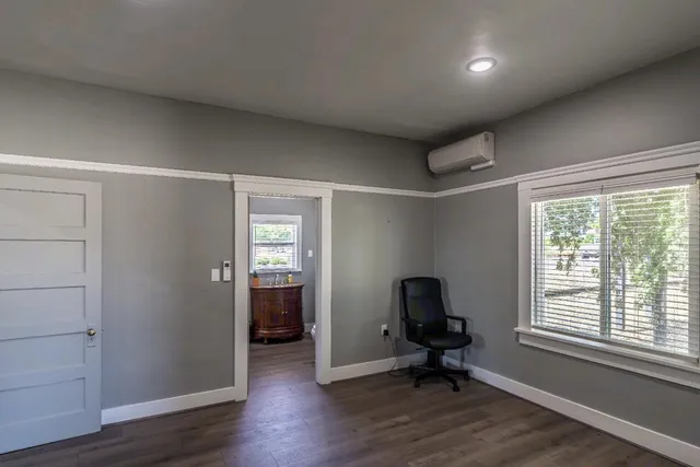 an empty room with wooden floor & closet area