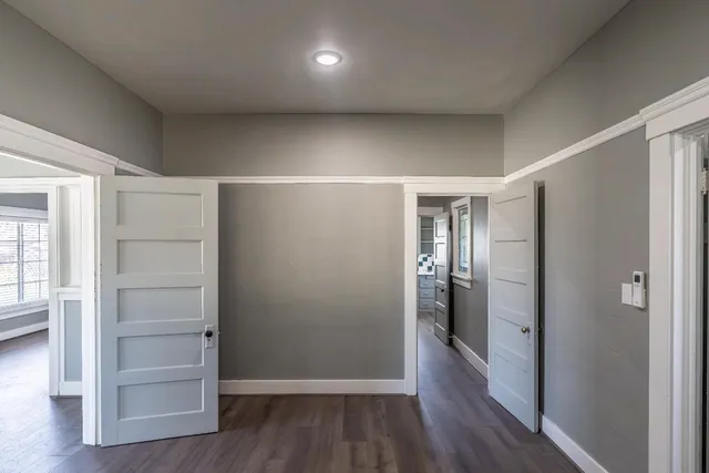 a view of a hallway with wooden floor and windows