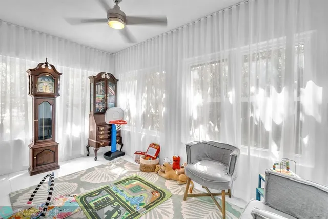 a bedroom with a bed and a baby crib next to a window