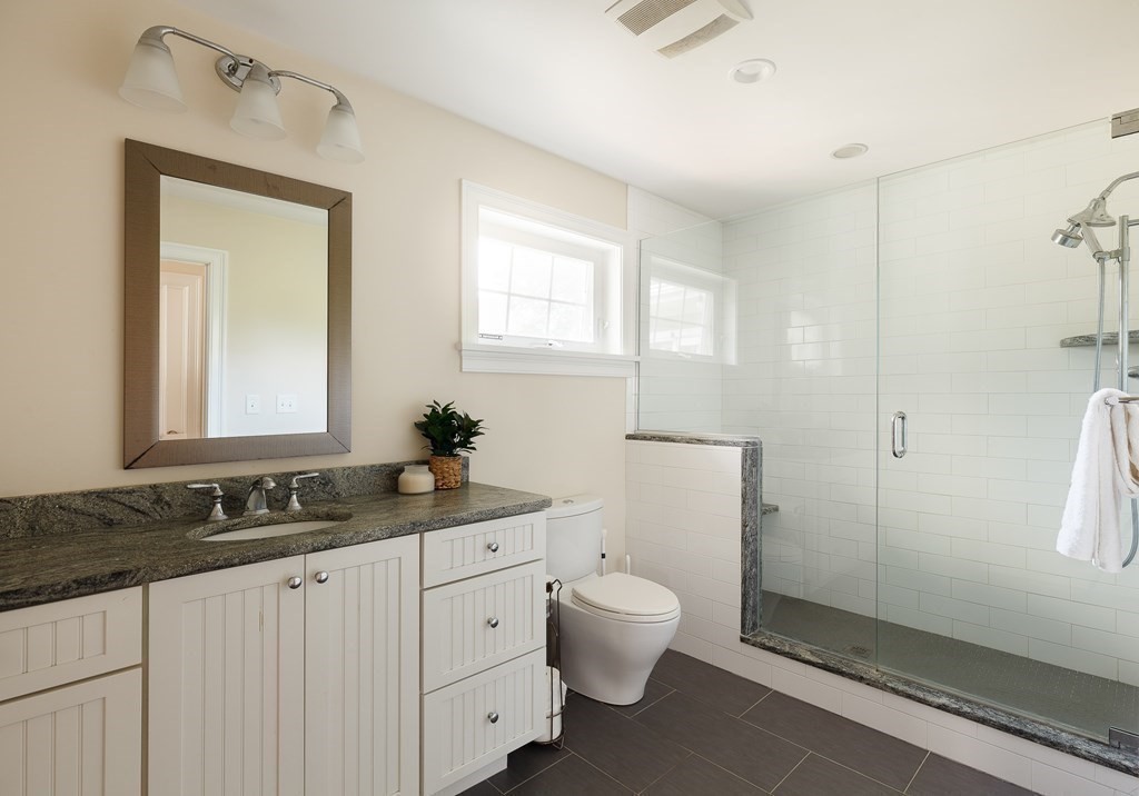 79 Bay State Road Arlington, MA 02474 - Photo 12 of 31 a bathroom with a granite countertop sink a toilet and a mirror