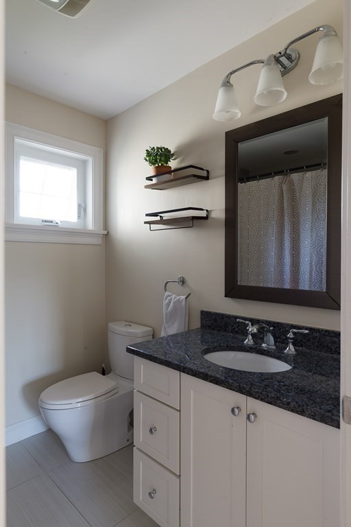 79 Bay State Road Arlington, MA 02474 - Photo 21 of 31 a bathroom with a granite countertop sink a toilet and mirror