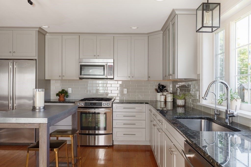 79 Bay State Road Arlington, MA 02474 - Photo 5 of 31 a kitchen with granite countertop a stove a sink and a microwave
