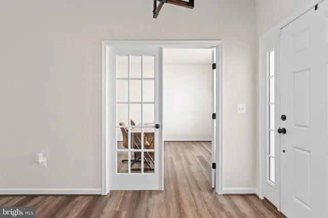 a kitchen with stainless steel appliances a refrigerator a stove a sink and white cabinets with wooden floor