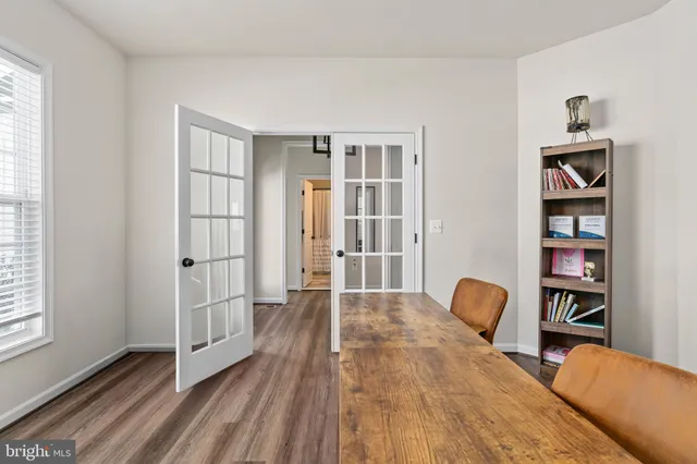 a kitchen with stainless steel appliances a dining table chairs refrigerator and cabinets
