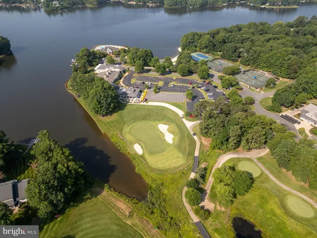 an aerial view of a house with a yard and lake view