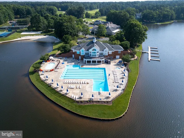 an aerial view of a swimming pool with outdoor seating and yard