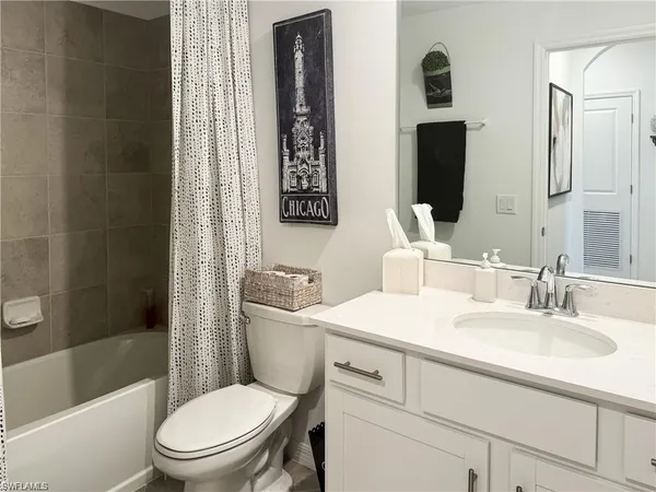 a bathroom with a toilet a sink a mirror a bathtub and shower