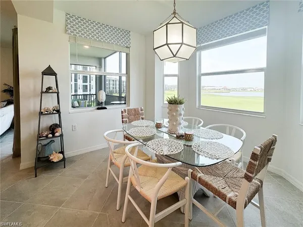 a dining room with furniture a chandelier and window