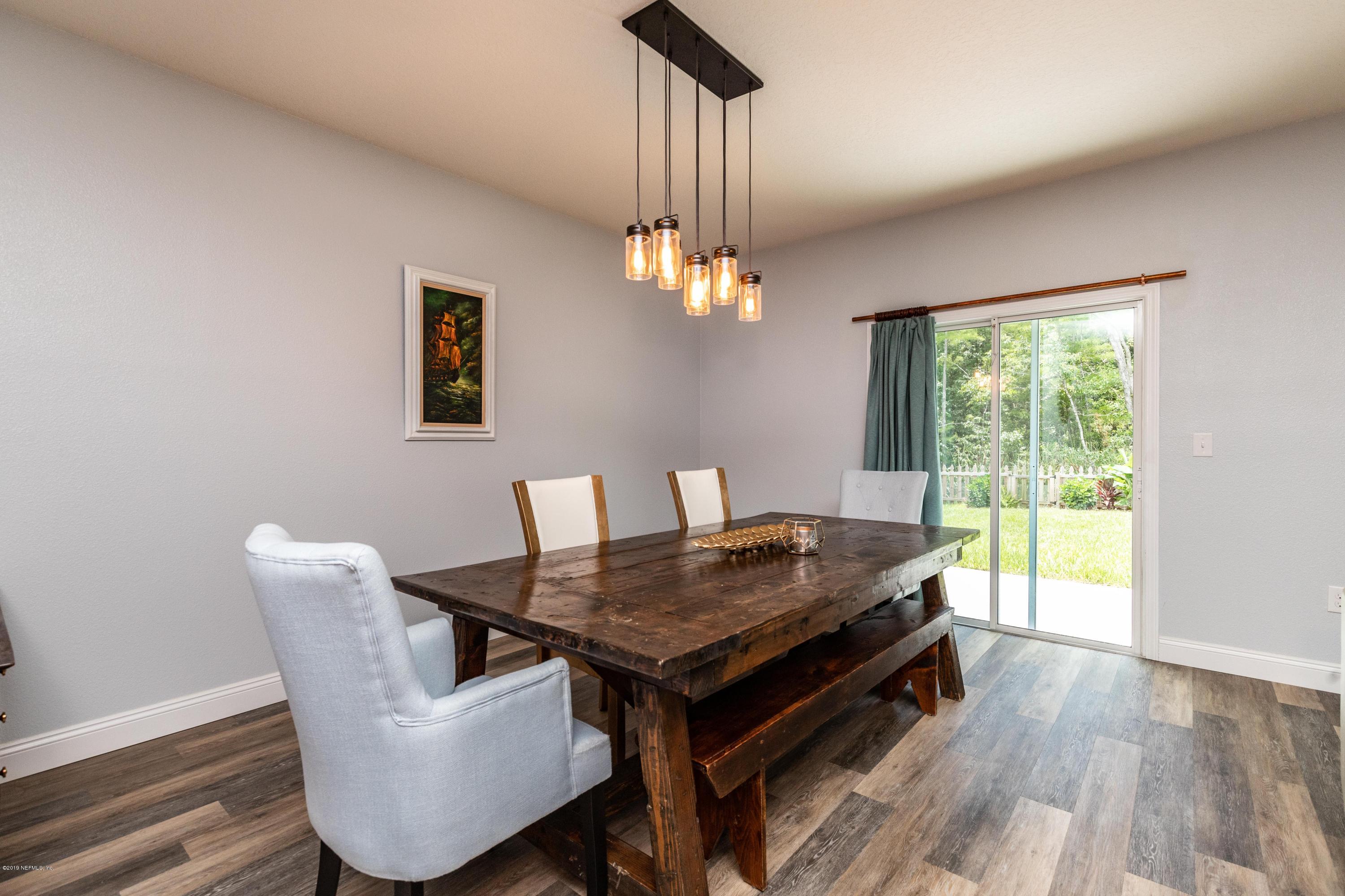 194 Ashby Landing Way St. Augustine, FL 32086 - Photo 12 of 41 a view of a dining room with furniture a chandelier and wooden floor