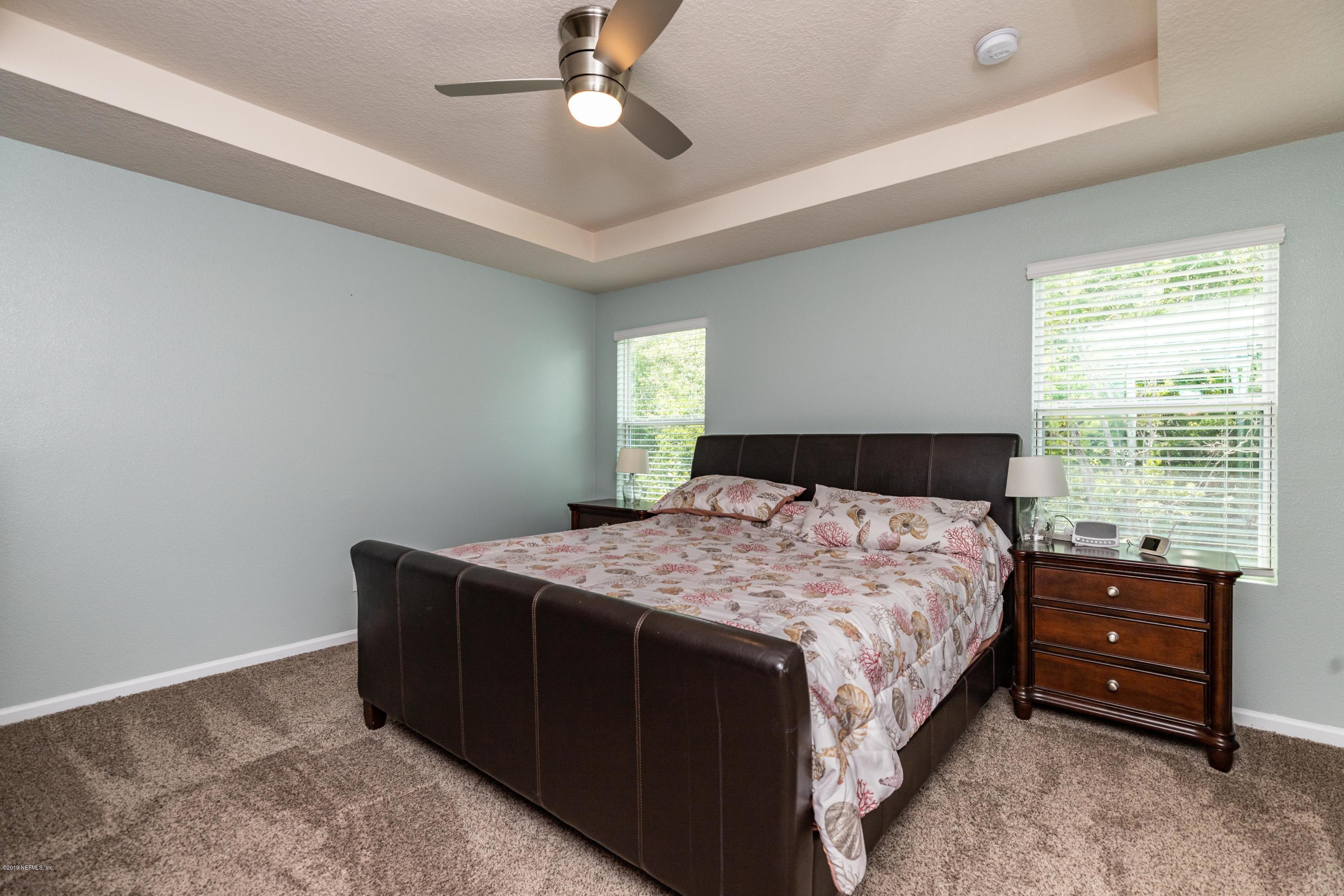 194 Ashby Landing Way St. Augustine, FL 32086 - Photo 27 of 41 a bedroom with a bed and a chandelier