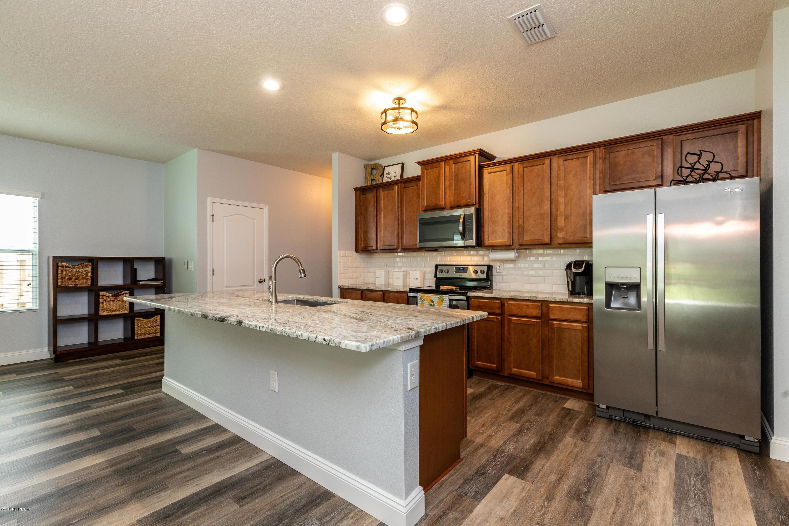 194 Ashby Landing Way St. Augustine, FL 32086 - Photo 10 of 41 a kitchen with stainless steel appliances granite countertop a refrigerator a sink dishwasher a stove and white cabinets with wooden floor